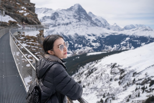 グリンデルワルト最初のスイス xAアルプスの景色を望むグリンデルワルトの最初の山にあるファースト・クリフ・ウォーク展望台の女性