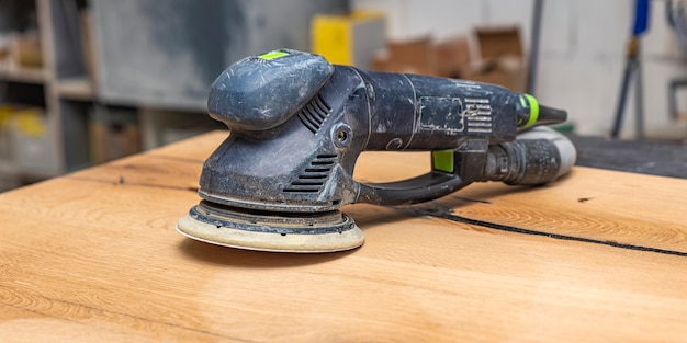 Grinder voor hout op een houten tafel. Schrijnwerkers slijpmachines, meubelproductie. plaats om tekst in te voegen.