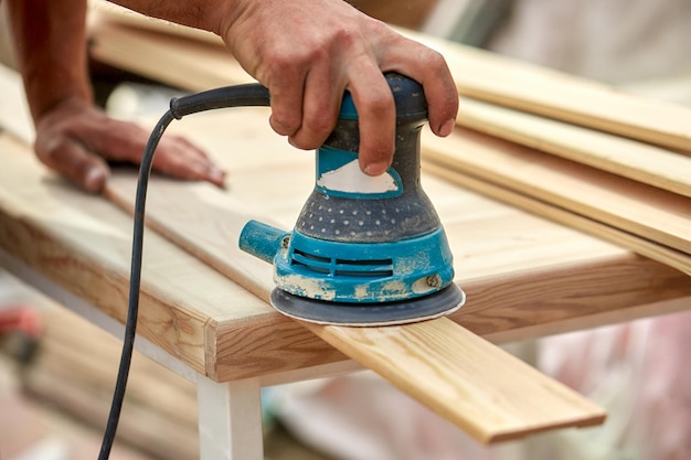 Grinder worker polishes a wooden board Sanding boards Orbital eccentric machine