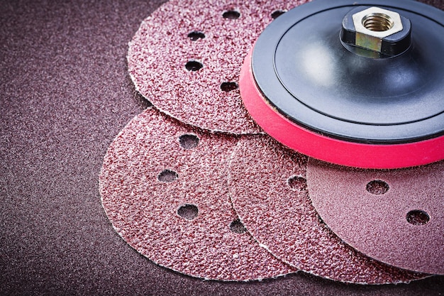 Grinding discs holder on sandpaper sheet abrasive materials.