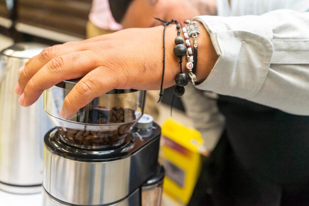 국제 커피의 날에 경의를 표하는 컵핑 행사에서 프리미엄 원두를 갈기