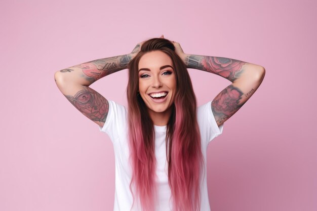 A grinning Caucasian woman with long pinktipped tresses and tattoos on her arms wears a white informal tee while covering her face with her hair