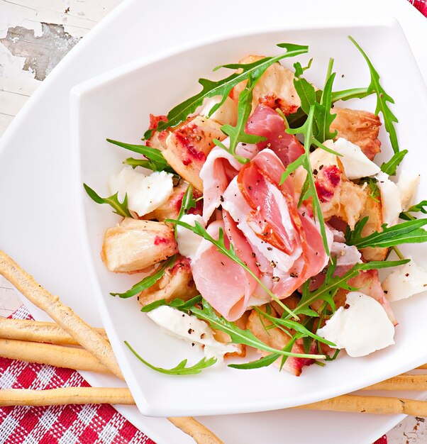 Grissini bread sticks with ham, tomato and basil