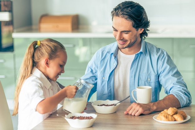 Grlと彼女の父親は、自宅のキッチンで朝食をとっています。