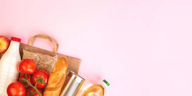 Groceries with healthy food on pink background