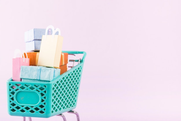 Grocery cart with colourful gift boxes and shopping bags