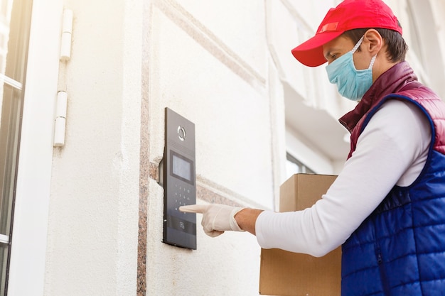 Grocery delivery man wearing medical gloves and face mask.\
online shopping and delivery for grocerys, wine and food. self\
quarantine during coronavirus pandemic. food delivery service\
courier