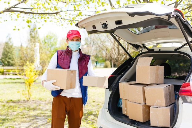 Grocery delivery man wearing medical gloves and face mask.\
online shopping and delivery for grocerys, wine and food. self\
quarantine during coronavirus pandemic. food delivery service\
courier