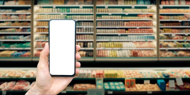 Продуктовый онлайн телефон с рукой на фоне супермаркета с продуктами высокого качества фото