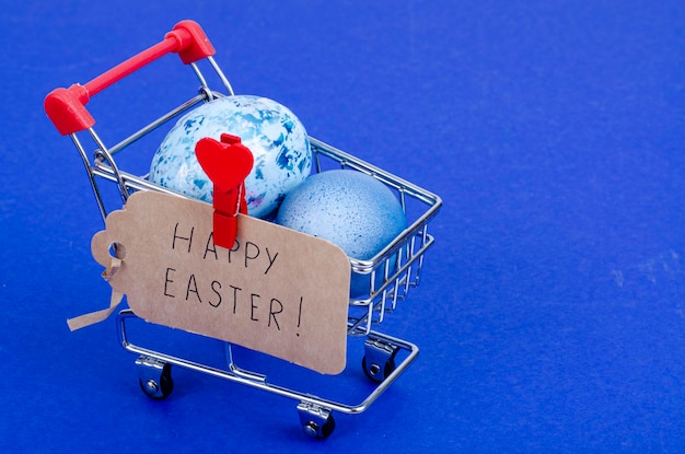 Grocery supermarket cart filled with chicken eggs. Concept of preparing for Easter, buying food. Space for text. Studio Photo