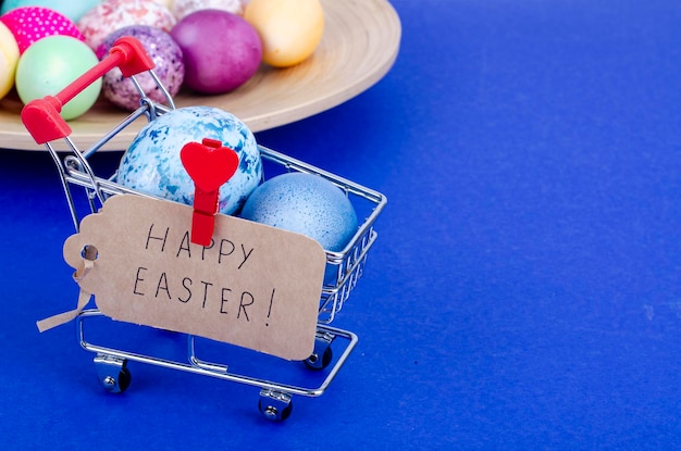 Carrello del supermercato di generi alimentari pieno di uova di gallina. concetto di preparazione per la pasqua, acquisto di cibo. spazio per il testo. studio fotografico