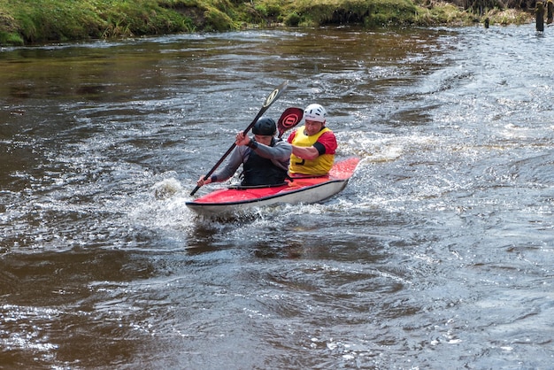 GRODNO BELARUS APRIL 2018 kayak freestyle competition on fast cold water river strenuously rowing spirit of victory