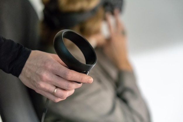 Photo grodno belarus june 012020 a young girl and a young guy use virtual reality glasses to play games or present new technologies the operator girl is holding a smartphone and a controllers use vr