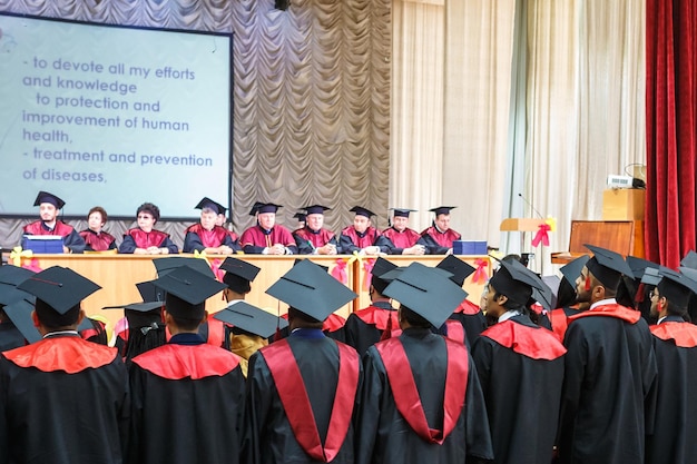 GRODNO BELARUS JUNE 2018 Foreign medical students in square academic graduation caps and black raincoats during commencement