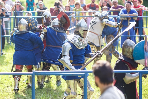 GRODNO BELARUS JUNE 2019 group of medieval jousting knight fight in armor helmets chain mail with axes and swords on lists historic reconstruction of ancient fight