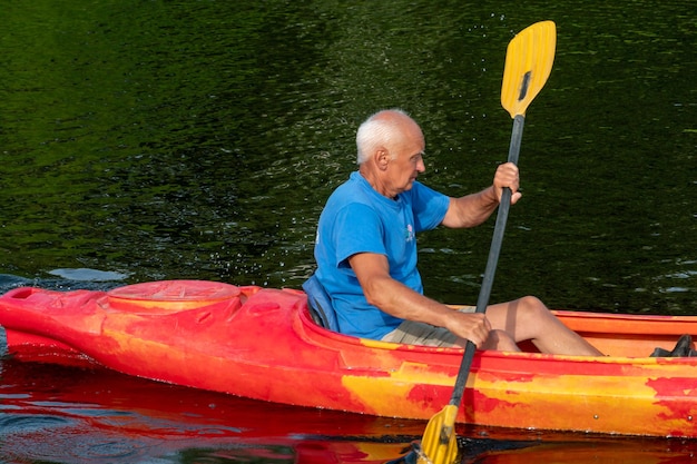 Foto grodno bielorussia giugno 2021 un uomo anziano con un remo in mano sta facendo kayak sul fiume il concetto di ricreazione attiva e stile di vita sano