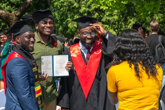 Гродно, Беларусь, июнь 2021 г. Три веселых афроамериканских студента улыбаются и позируют перед камерой во время выпускной церемонии Церемония вручения дипломов студентам