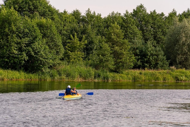 Grodno Belarus June 2021 Two young girls kayak along the river along picturesque places Kayak on the background of the forest The concept of active recreation and healthy lifestyle