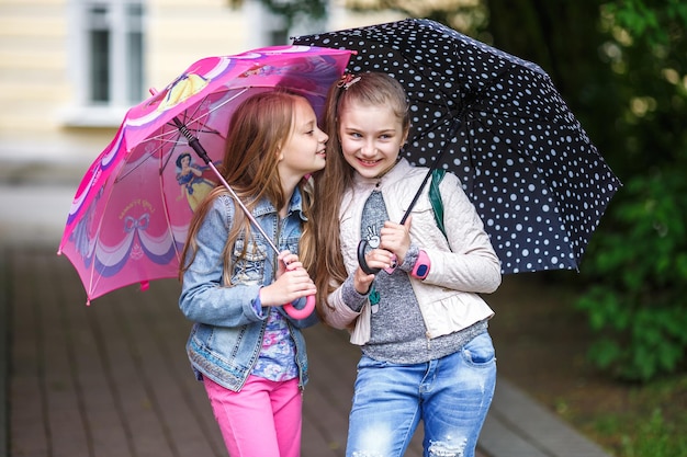 GRODNO 벨로루시 2018년 5월 공원에 우산을 들고 가십을 속삭이는 작고 아름다운 세련된 꼬마 소녀들의 초상화