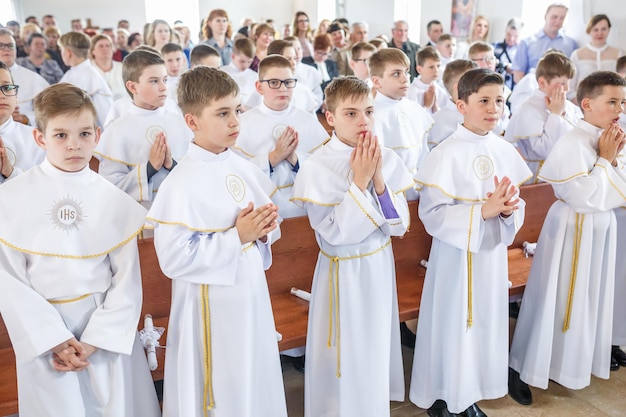 GRODNO BELARUS MAY 2019 Young children in the Catholic Church are waiting for the first eucharist communion Little angels in white clothes