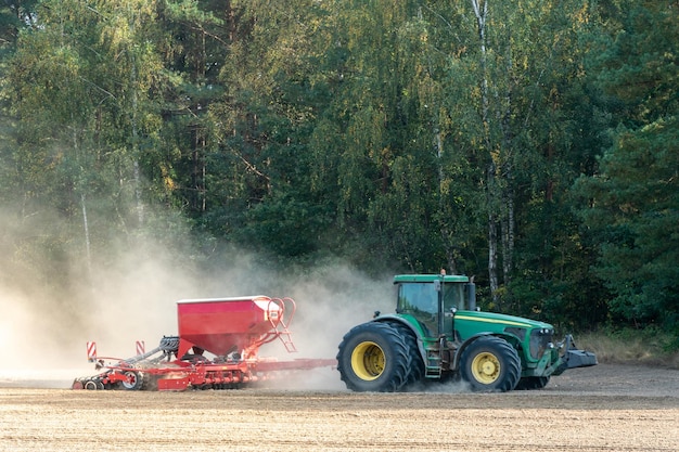 Grodno Wit-Rusland 22 juni 2020 Een boer die een tractor met een cultivator bestuurt, bereidt het land voor als onderdeel van het voorzaaiwerk aan het begin van het lenteseizoen van landbouwwerk op het land
