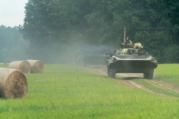 Grodno Wit-Rusland 25 juli 2020 infanteriegevechtsvoertuig rijdt op een onverharde weg langs een veld tegen de achtergrond van een bos met soldaten aan boord Diverse militaire uitrusting bij de oefeningen