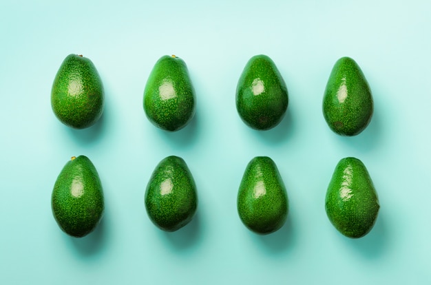 Groen avocadopatroon op blauwe achtergrond. Biologische avocado&#39;s in een minimale platte lay-stijl.