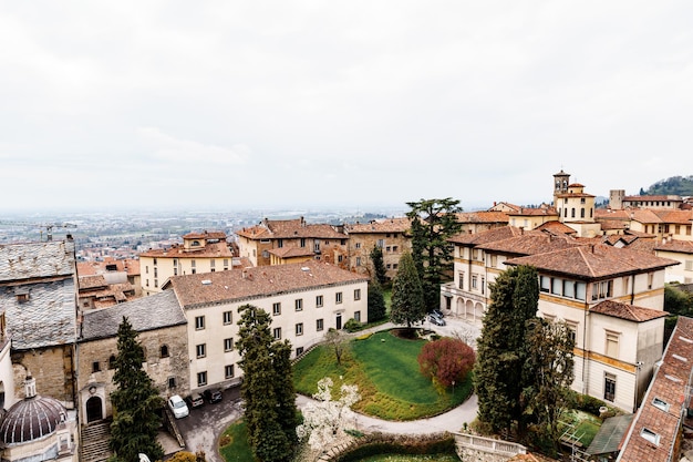 Groen bloembed onder oude huizen in het bovenaanzicht van bergamo