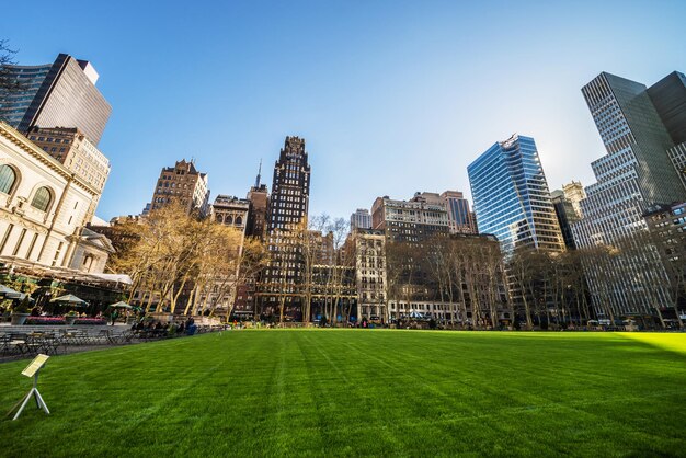 Groen gazon en wolkenkrabbers in Bryant Park in Midtown Manhattan, New York, NYC, VS. Toeristen ontspannen in het park