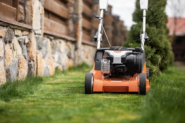 Groen gras maaien op een zonnige lentedag met nieuwe grasmaaier