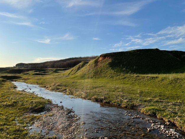 Groen gras op een kleine heuvel met een heldere stroom