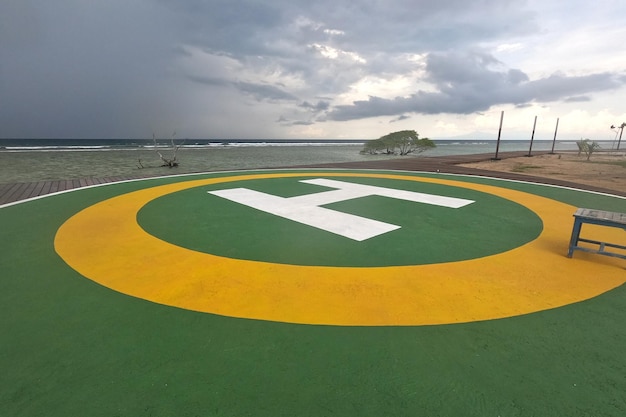 Groen helikopterdekbord voor privé aan het strand van het resort onder een sombere hemel