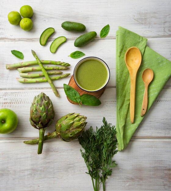 Groen keukengerei en groenten op de artisjokken van de houten vloeravocado