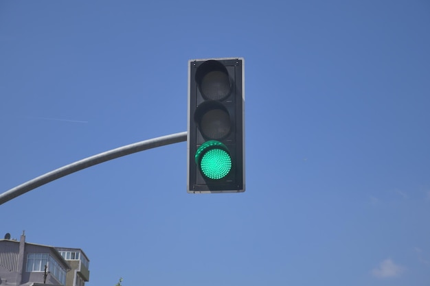 Groen kleurenverkeerslicht tegen blauwe achtergrond