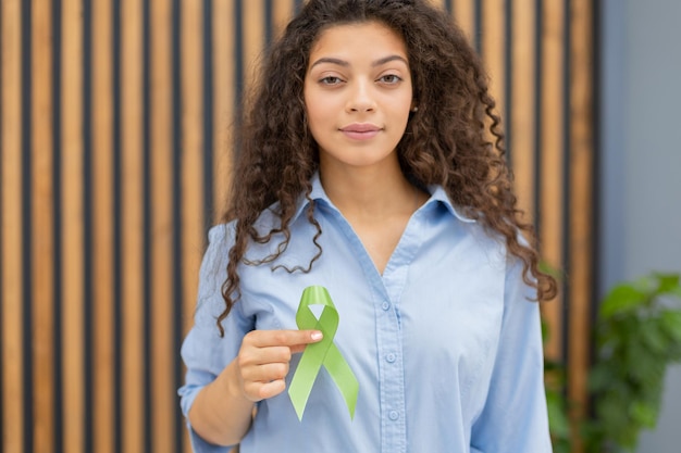 Groen lint in de hand als symbool voor bewustzijn lymfoomkanker