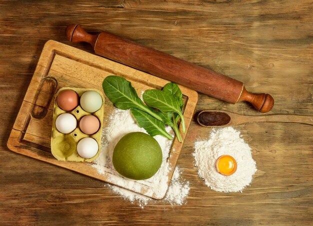 Groen noedeltje met ingrediënten op tafel.