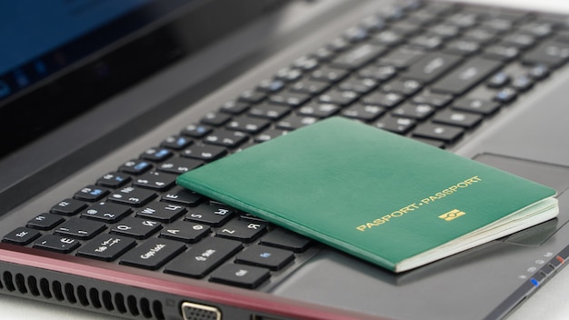 Groen paspoort op het toetsenbord van de laptop. Online registratie