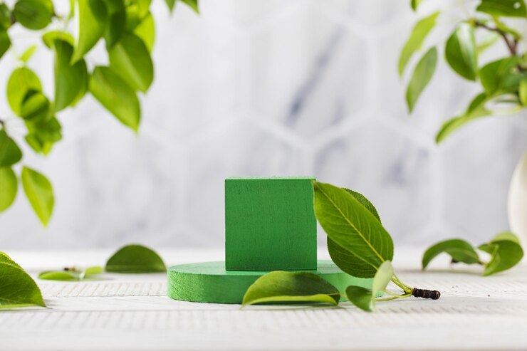 Groen podium omringd door jonge bladeren voor productpresentatie op een houten ondergrond Het biologische concept