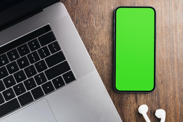 Groen scherm op het smartphonescherm op de houten tafel Kantooromgeving Chroma Key