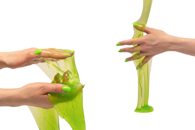 Groen slijm speelgoed in de hand van een vrouw met groene nagels geïsoleerd op een witte achtergrond