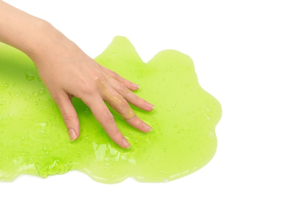 Groen slijmstuk speelgoed in vrouwenhand die op wit wordt geïsoleerd.