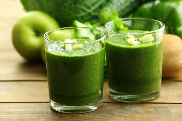 Groen vers gezond sap met fruit en groenten op houten tafel achtergrond