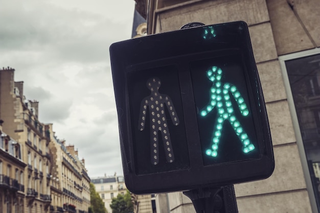 Groen voetverkeerslicht in de stadsstraten van parijs