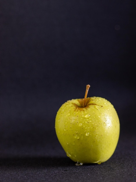 Groene appel met druppels op zwarte achtergrond