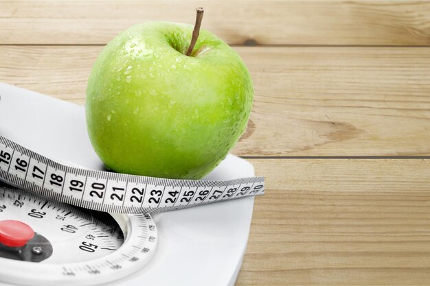 Groene appel met meetlint geïsoleerd op houten tafel