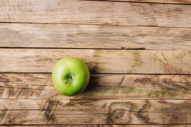 Groene appel op de rustieke houten mening van de lijstbovenkant