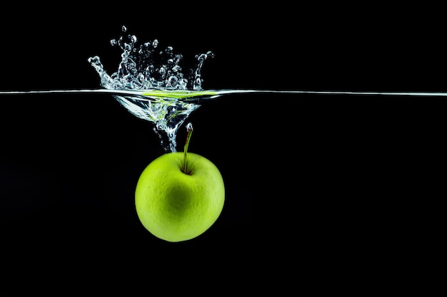 Groene appel vallen in water met een plons tegen donkere close-up