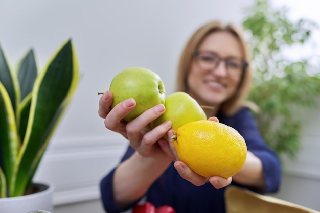 Groene appels en citroen in de handen van een vrouwelijke voedingsdeskundige, gezond etend natuurlijk fruit Nuttriciology