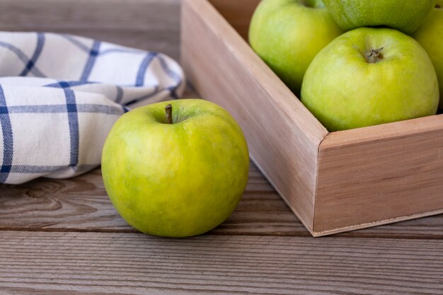 Groene appels in een doos op een houten tafel