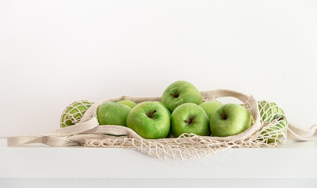 Groene appels in een koordzak op een witte achtergrond